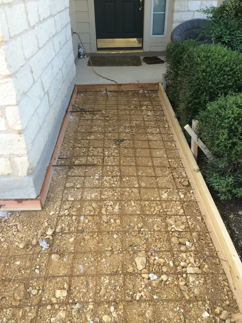 Formed and prepped walkway base beside a home