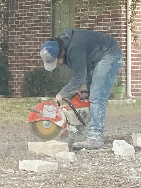 Mason cutting stone with a cutoff saw