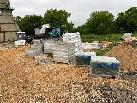 Pallets of block and sand staged for a build