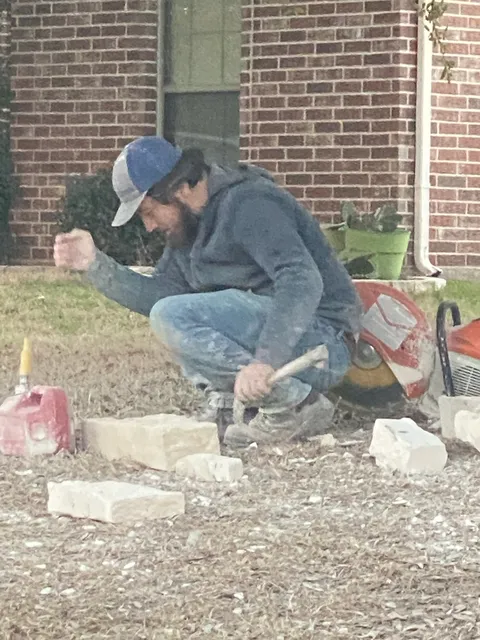 Mason cutting stone at a mailbox build