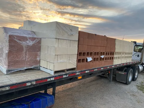 Flatbed of wrapped stone arriving at dusk