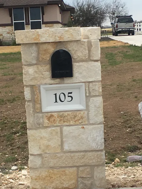 Finished stone mailbox with an address plate