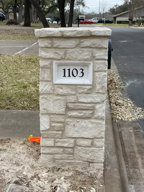 Finished stone mailbox with an address plaque