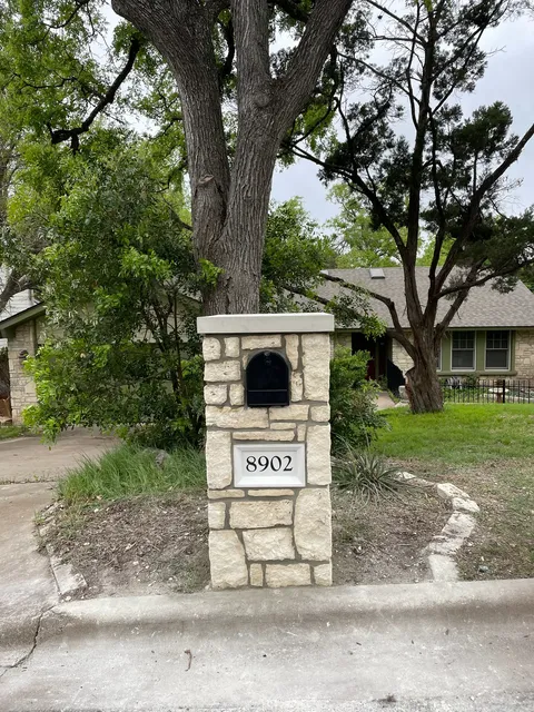 Stone mailbox column set under a live oak