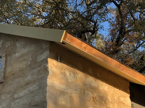 Stone gable end finished under a wood soffit