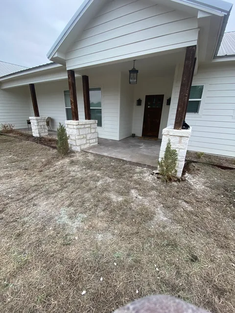 White farmhouse with stone veneer porch columns