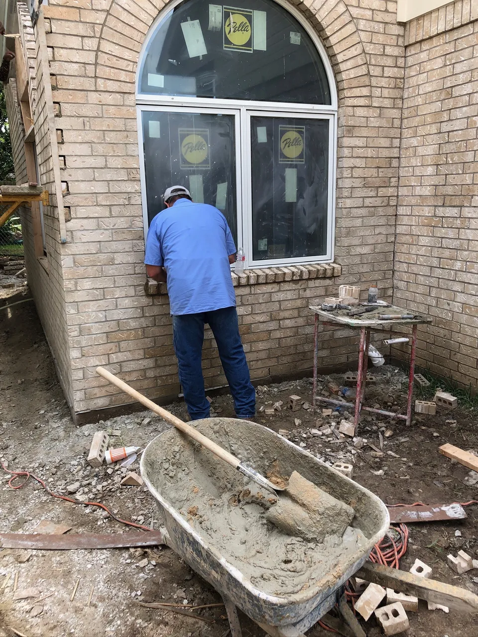 Puttrich & Sons mason installing stone veneer around an exterior window