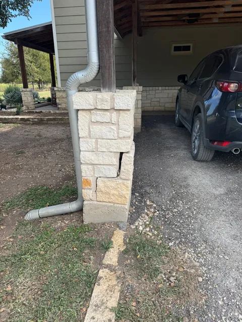 Stone veneer column and downspout at a home entry